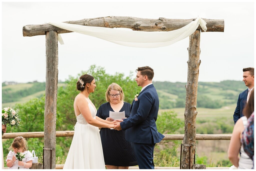 Tris & Jana - Lumsden Wedding - 17 - Bride & Groom standing under the altar overlooking the valley