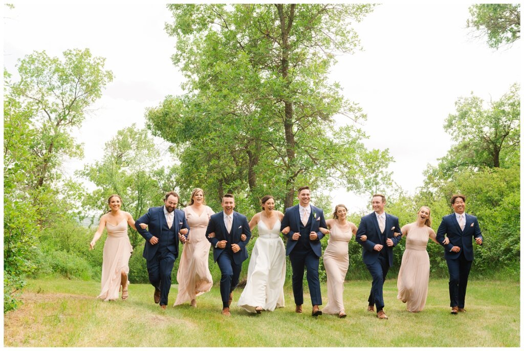 Tris & Jana - Lumsden Wedding - 21 - Bride & Groom link arms with their bridal party