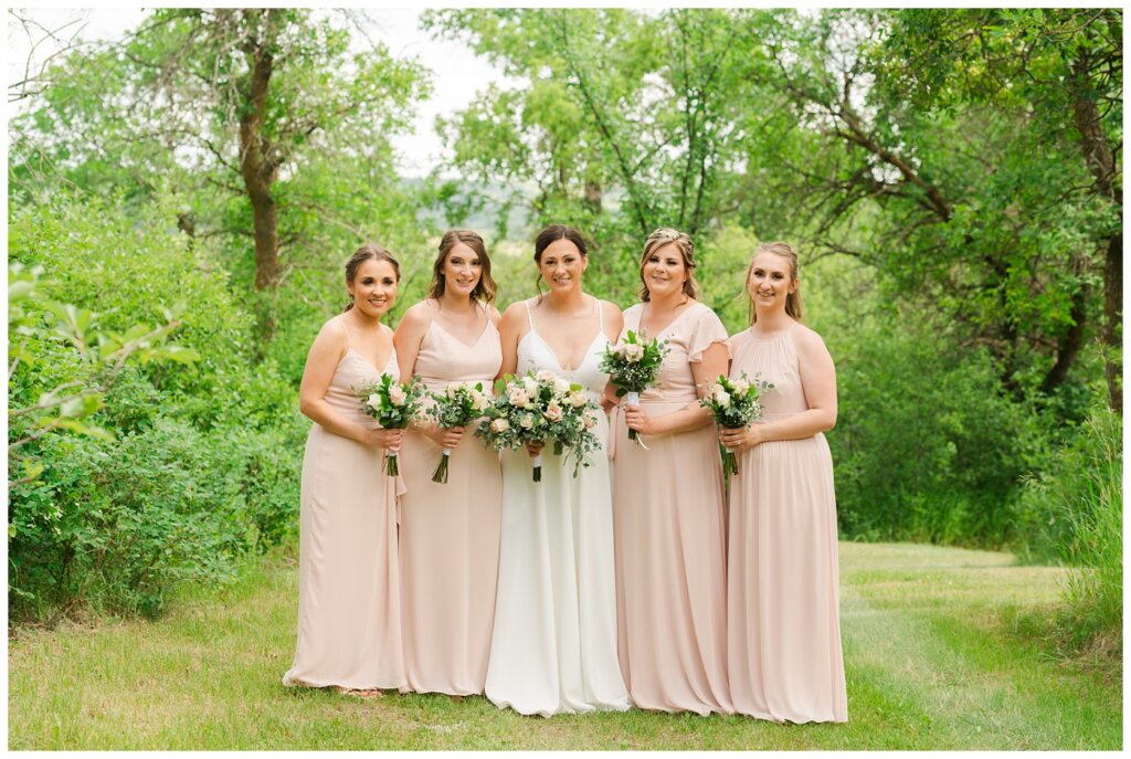 Tris & Jana - Lumsden Wedding - 22 - Bride stands with her bridesmaids in blush pink chiffon dresses