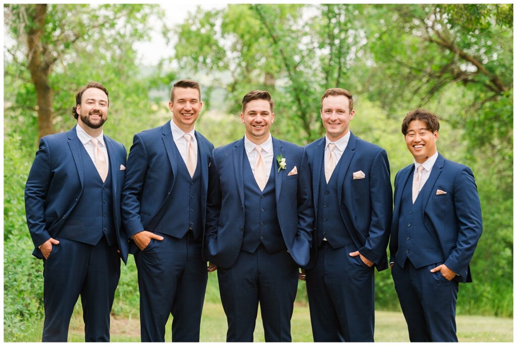 Tris & Jana - Lumsden Wedding - 26 - Groom & groomsmen stand in navy suits with blush ties