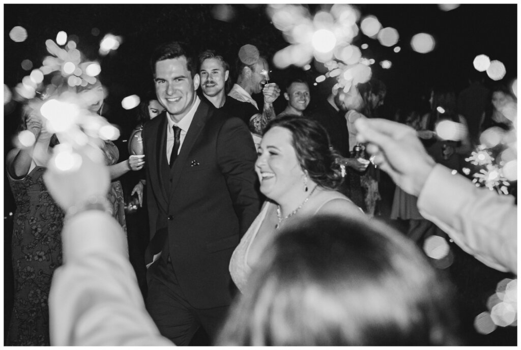 Ben & Megan - 32 - Regina Wedding - Guests hold up sparklers for bride & groom