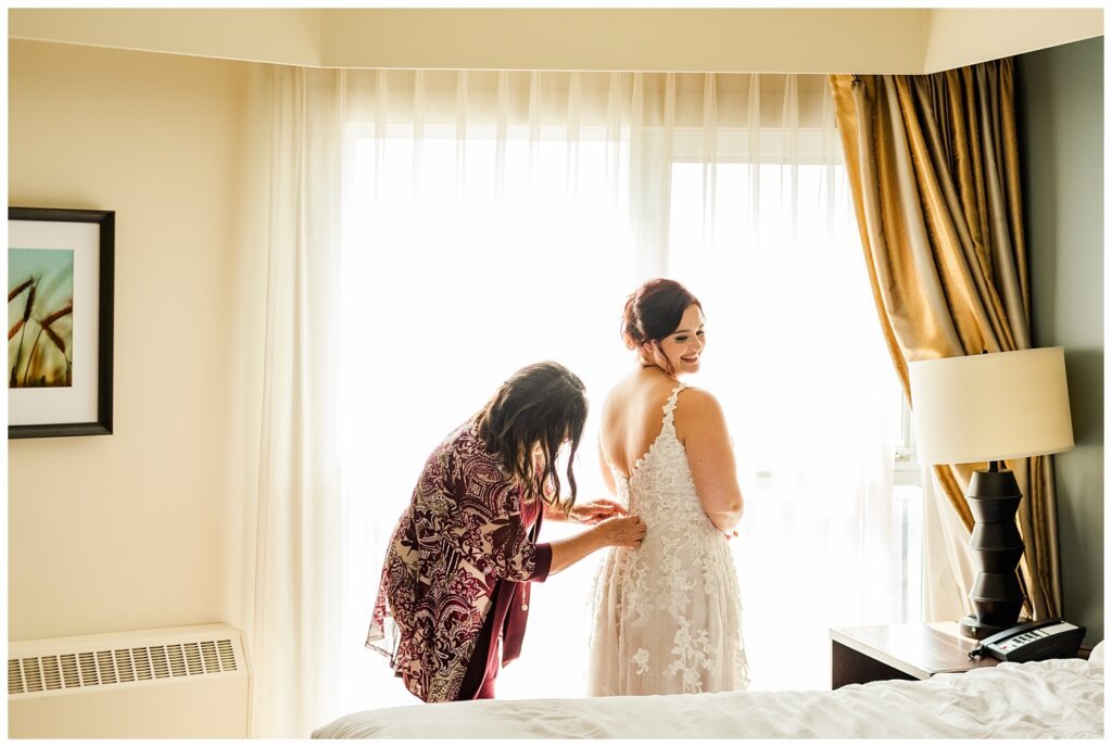 Andrew & Alisha - Regina Wedding Photography - 09 - Bride is helped into her Maggie Sottero gown by her mother