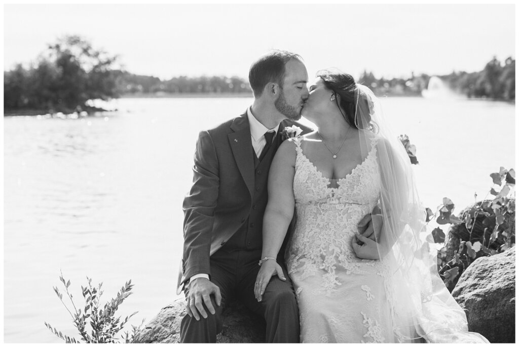 Andrew & Alisha - Regina Wedding Photography - 32 - Bride & Groom kiss by the lake at Willow Island Overlook