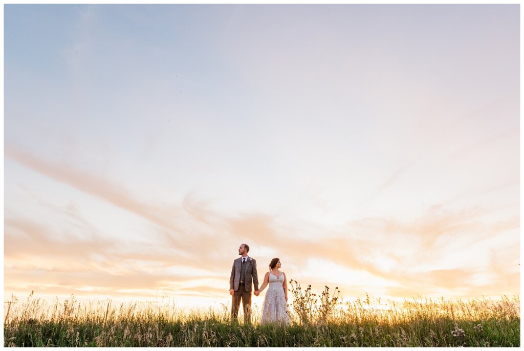 Andrew & Alisha - Regina Wedding Photography - 42 - Bride & Groom hold hands at sunset