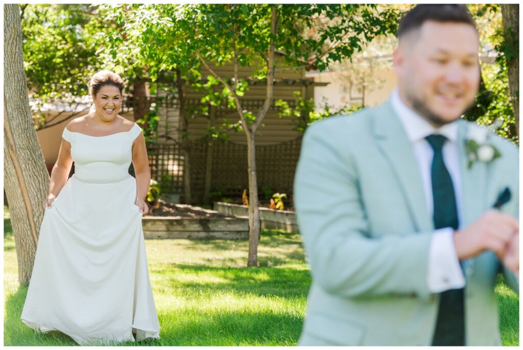 Declan & Katherine - 16 - Regina Wedding - Bride walks up behind groom for their first look