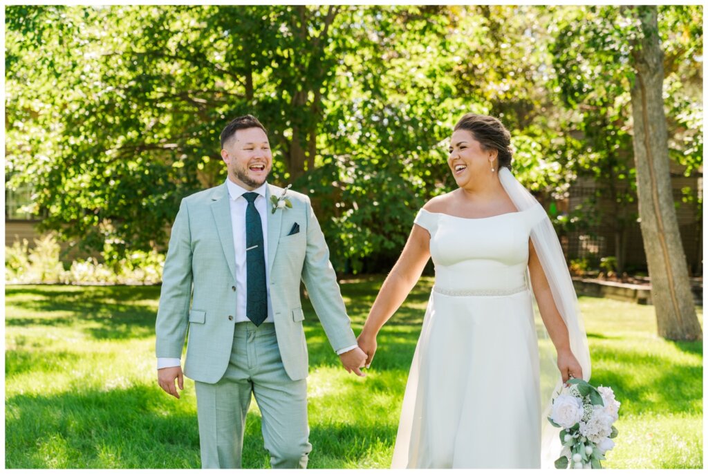 Declan & Katherine - 22 - Regina Wedding - Bride & groom walk holding hands