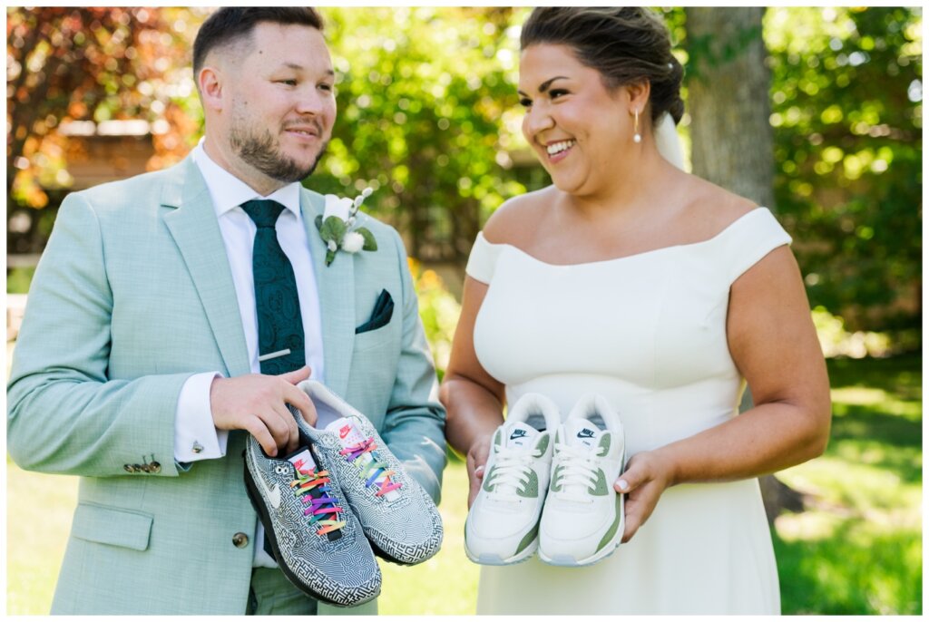 Declan & Katherine - 25 - Regina Wedding - Bride & groom hold their custom Nike Air Max 1 shoes