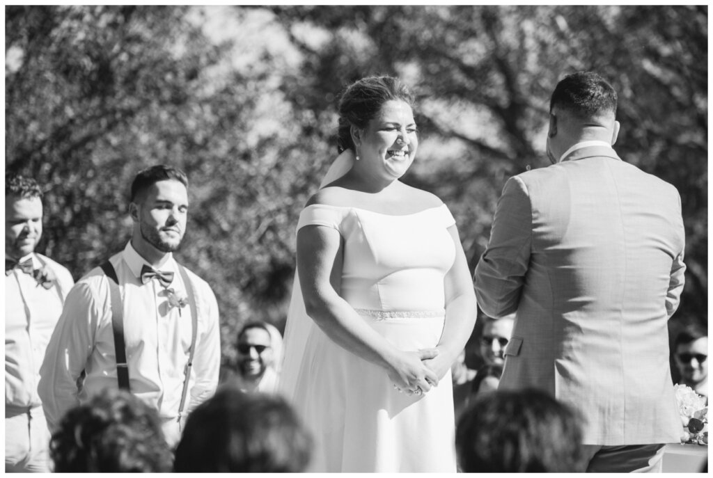 Declan & Katherine - 36 - Regina Wedding - Bride smiles as the officiant calls everyone to a moment of mindfulness