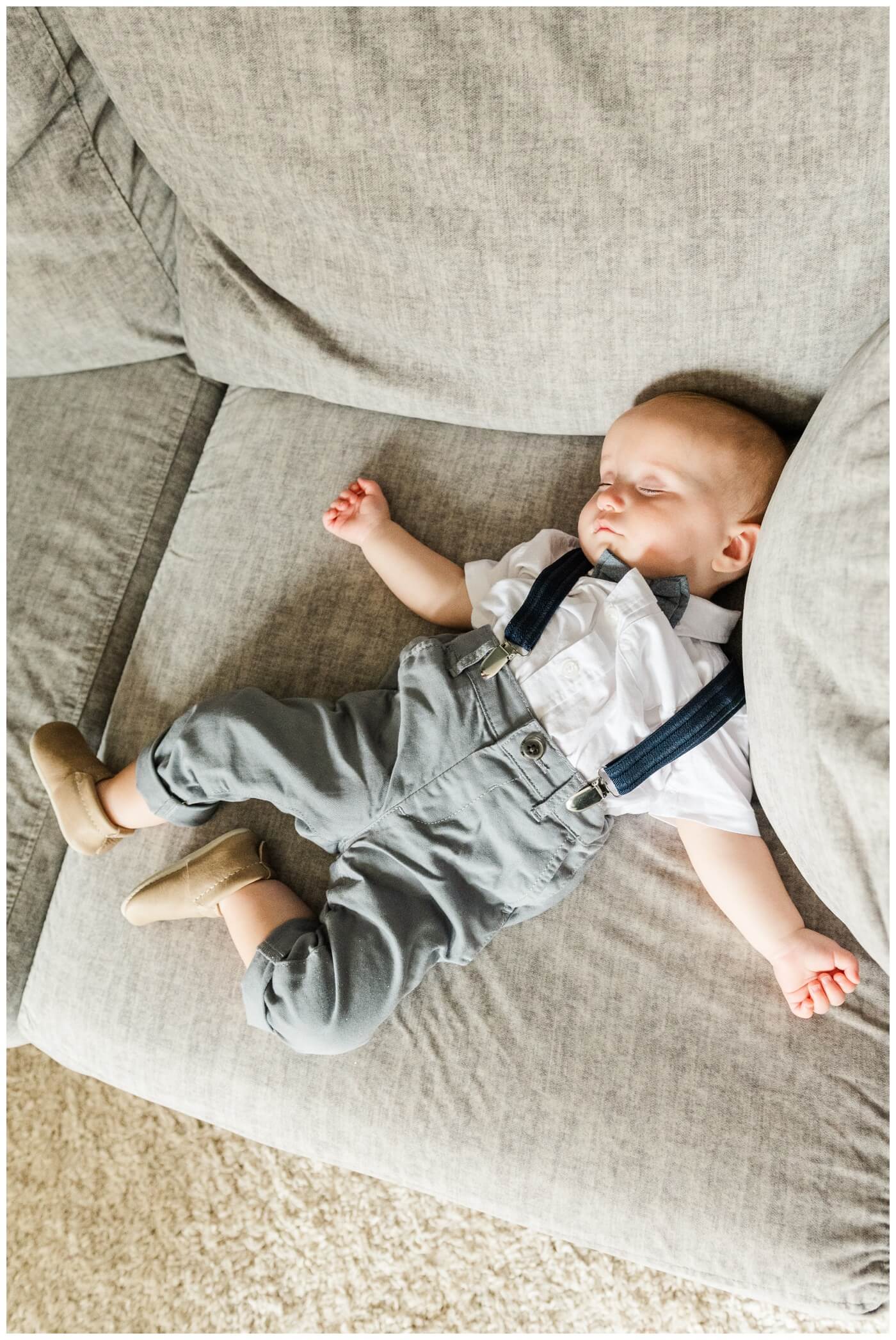 Adam & Caitlin - 09 - Regina Wedding - Baby sleeps on the couch in his grey suit pants and blue suspenders