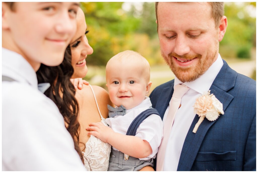 Adam & Caitlin - 24 - Regina Wedding - Youngest son smiles in the middle of a family hug