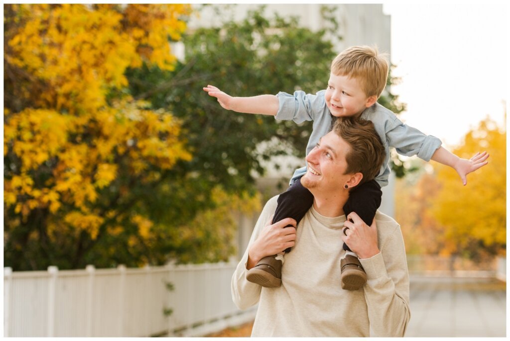 McFie Family - 07 - Regina Family Session Boy pretends to be an airplane atop dads shoulders