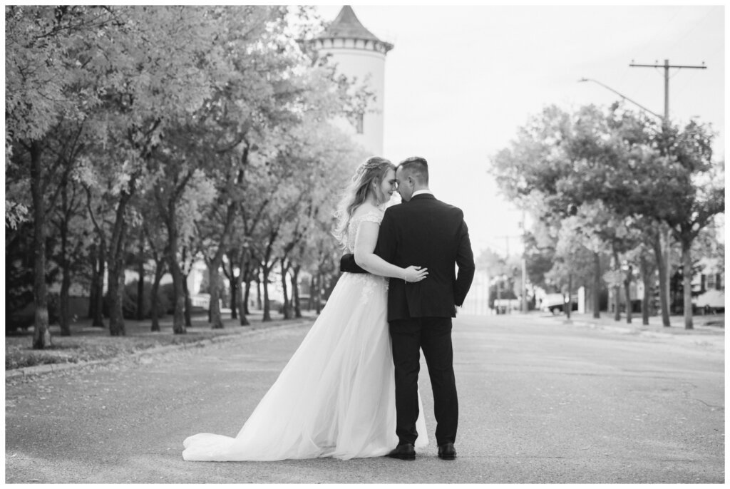 Orrin & Jade - 25 - Weyburn Wedding - Bride & Groom stand together in the street