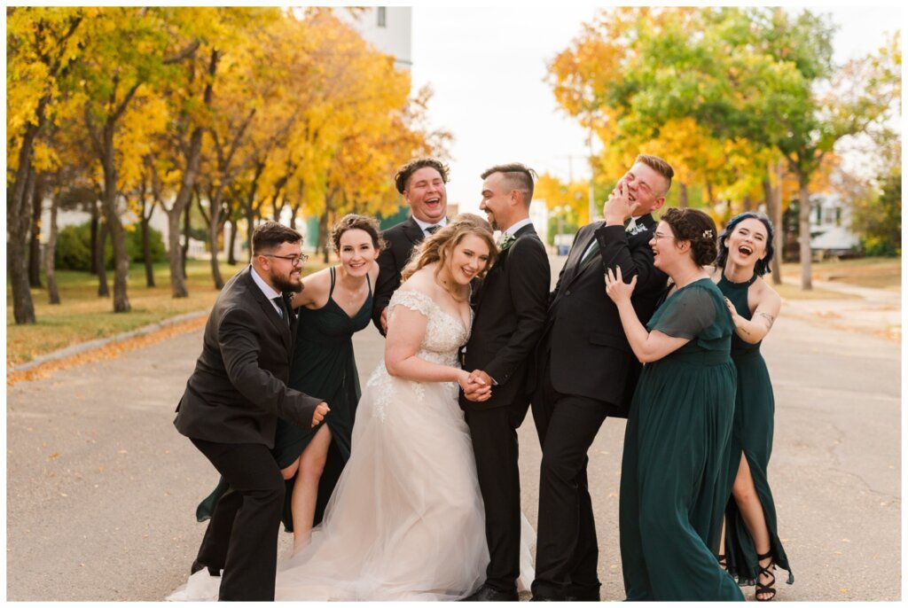 Orrin & Jade - 27 - Weyburn Wedding - Wedding party laughs in the street