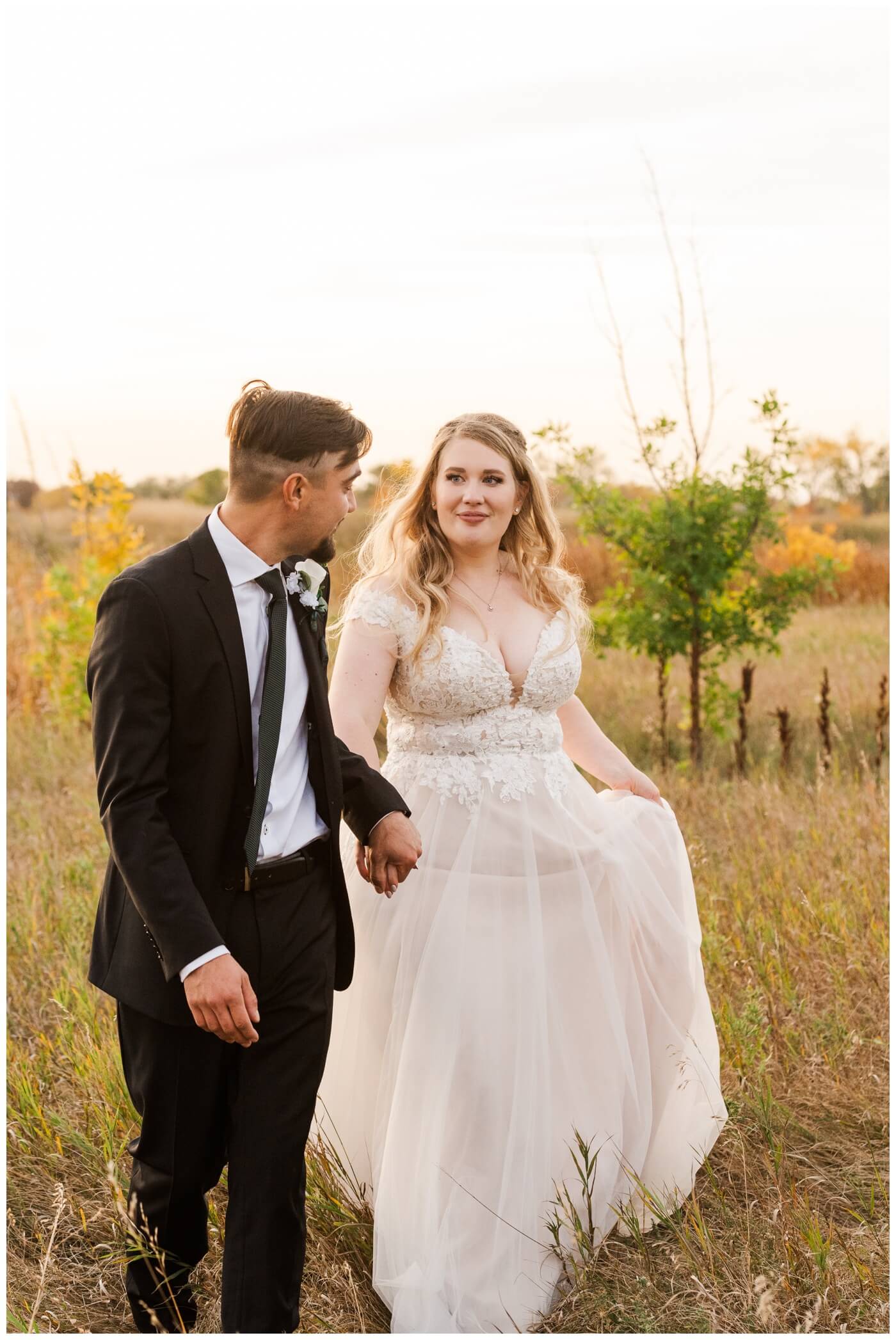 Orrin-Jade-35-Weyburn-Wedding-Groom-leads-his-bride-out-of-the-tall-grass-1