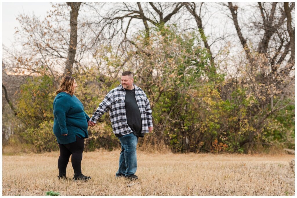 Scott & Ashley - 05 - Husband leads his wife as they walk through the tall grass