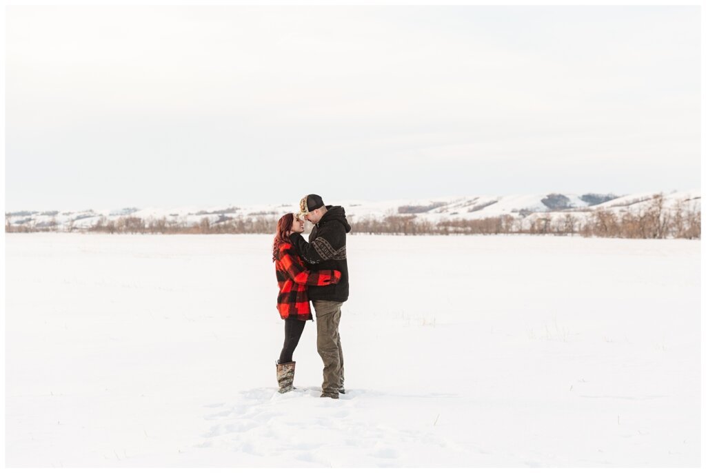 Brett & Brittany - Winter 2023 - Lumsden Valley - 10 - Couple stand in the snow amidst the Lumsden Valley