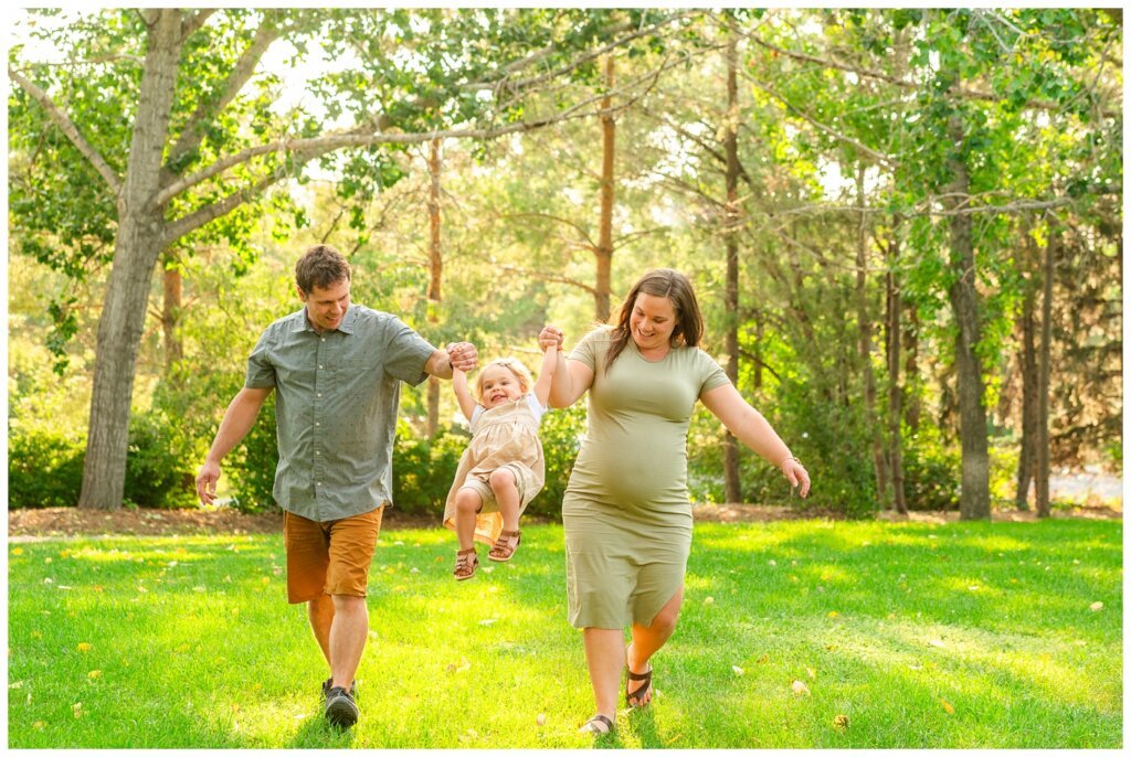 Filby Family 2023 - 05 - Mom and dad swing their daughter in the park