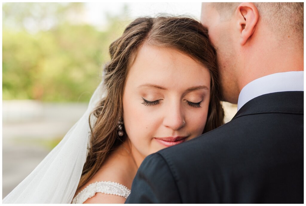 Ryan & Melissa - Hotel Sask Wedding - 11 - Bride cuddling into groom's shoulder
