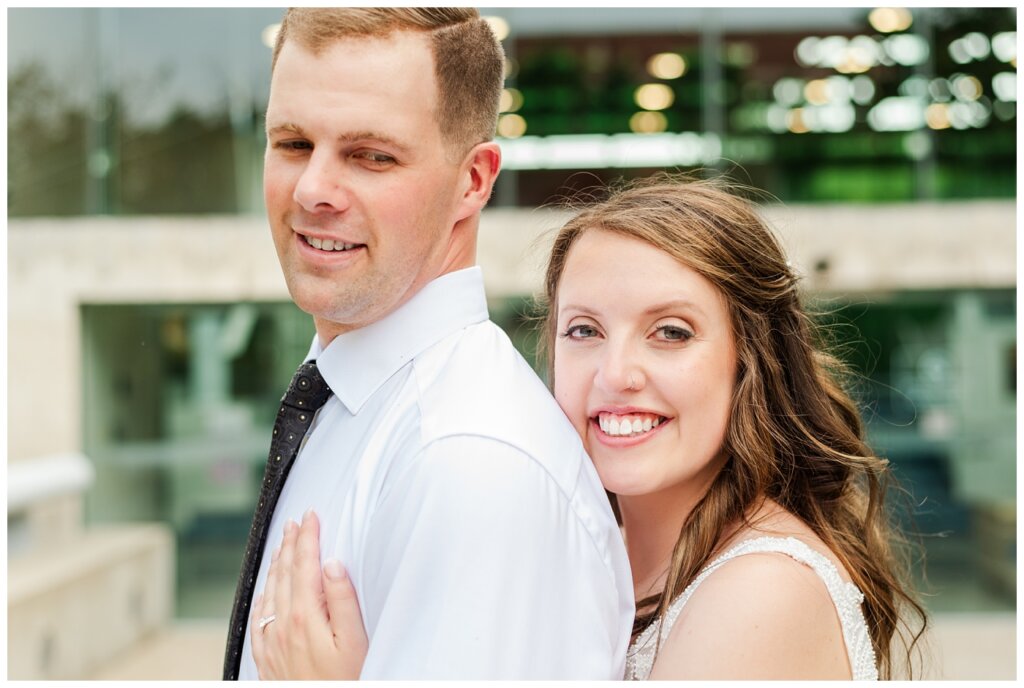 Ryan & Melissa - Hotel Sask Wedding - 18 - Bride snuggling into groom's back looking at camera