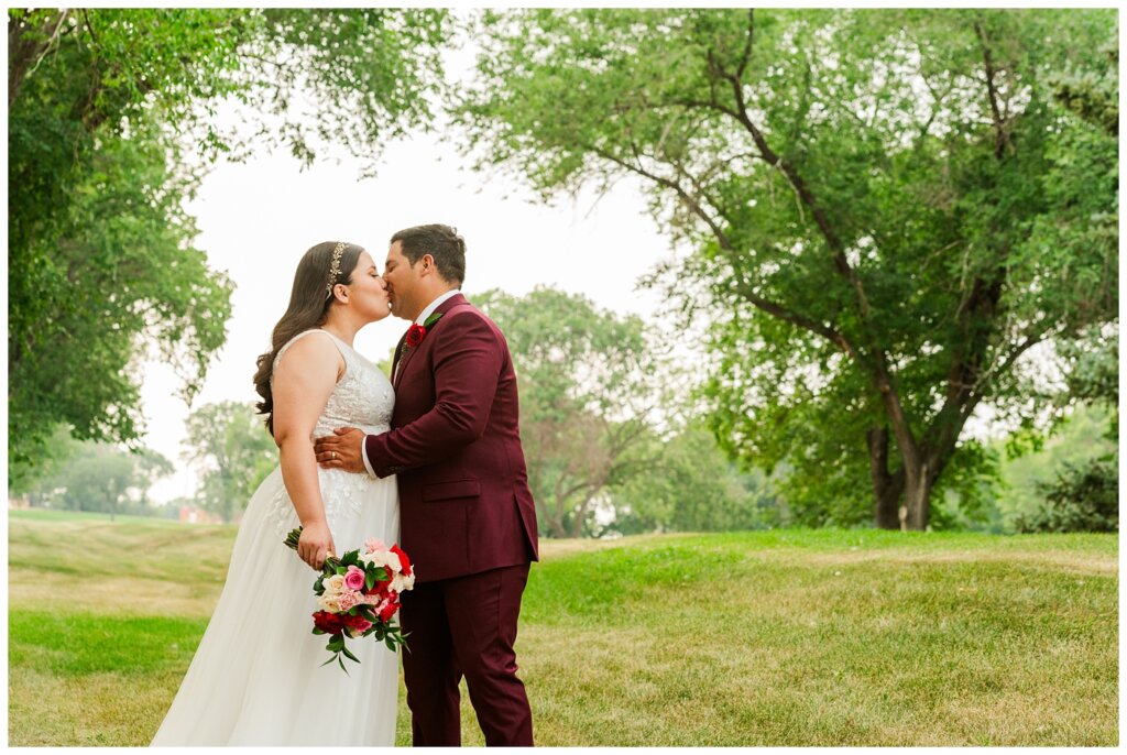 Luis & Keila - Summer wedding 2023 - Les Sherman Park - 06 - Groom plants a kiss on his wife