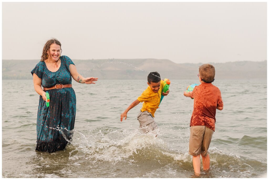 Jaarsma Family - Lumsden Beach - 18 - Little boy shoots water at his mom