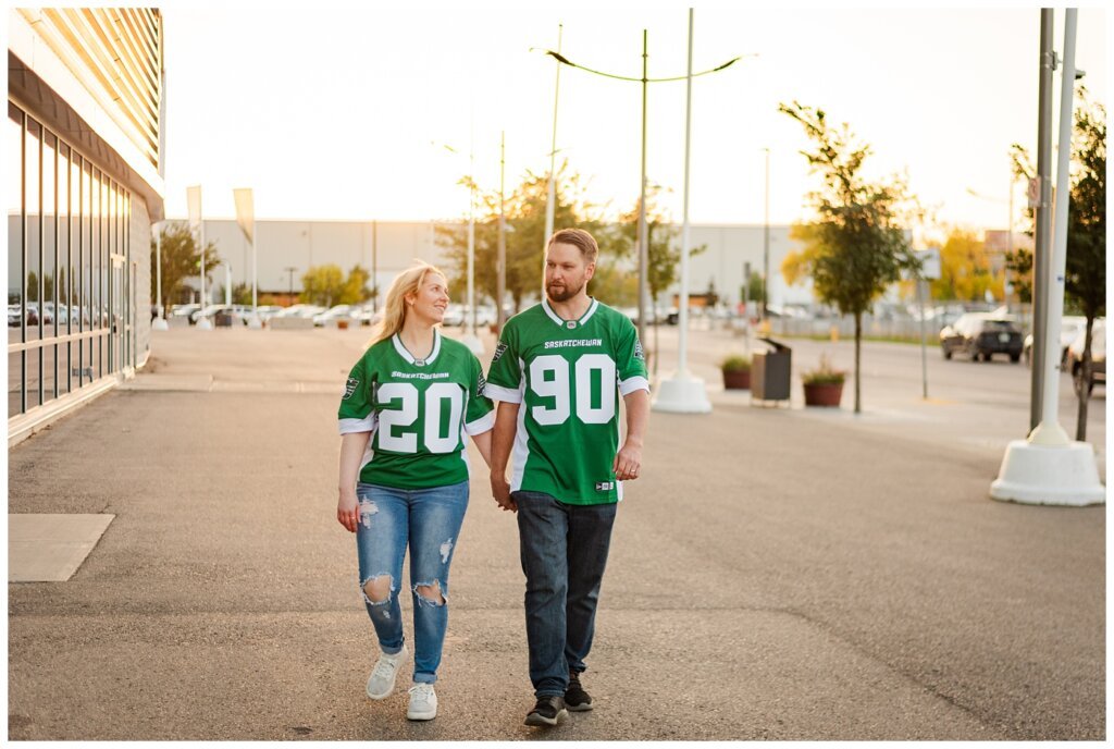 Lindskog Family - Mosaic Stadium - 08 - Couple walks wearing new Rider jerseys