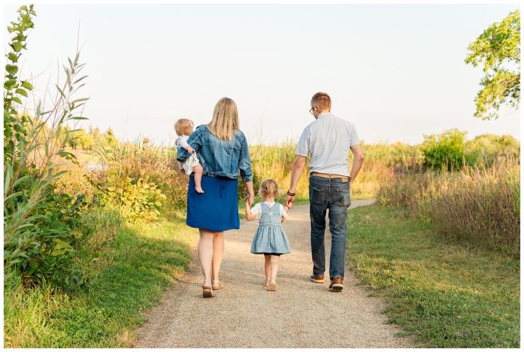 Parsons Family - AE Wilson Park - 12 - Family holds hands as they walk down the path