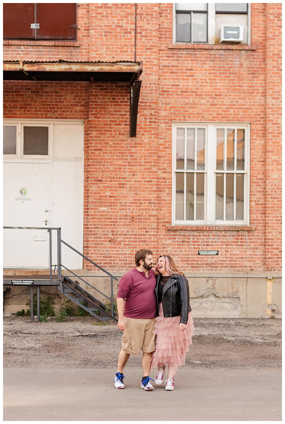 TJ & Danielle - Regina Warehouse District - 01 - Couple laughs in alley