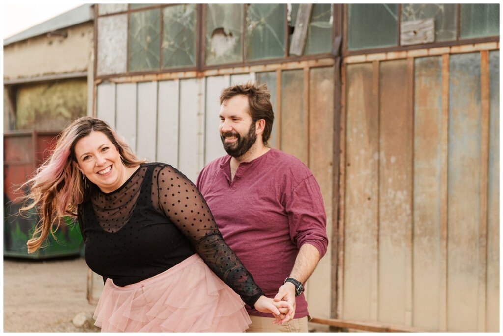 TJ & Danielle - Regina Warehouse District - 13 - Couple stands in front of metal building