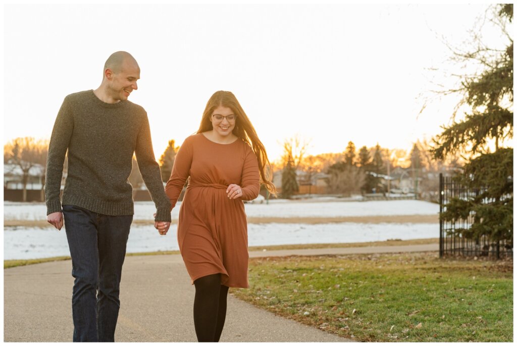 Evan & Melissa - Winter Engagement - Parkridge Park - 10 - Couple skip down the path