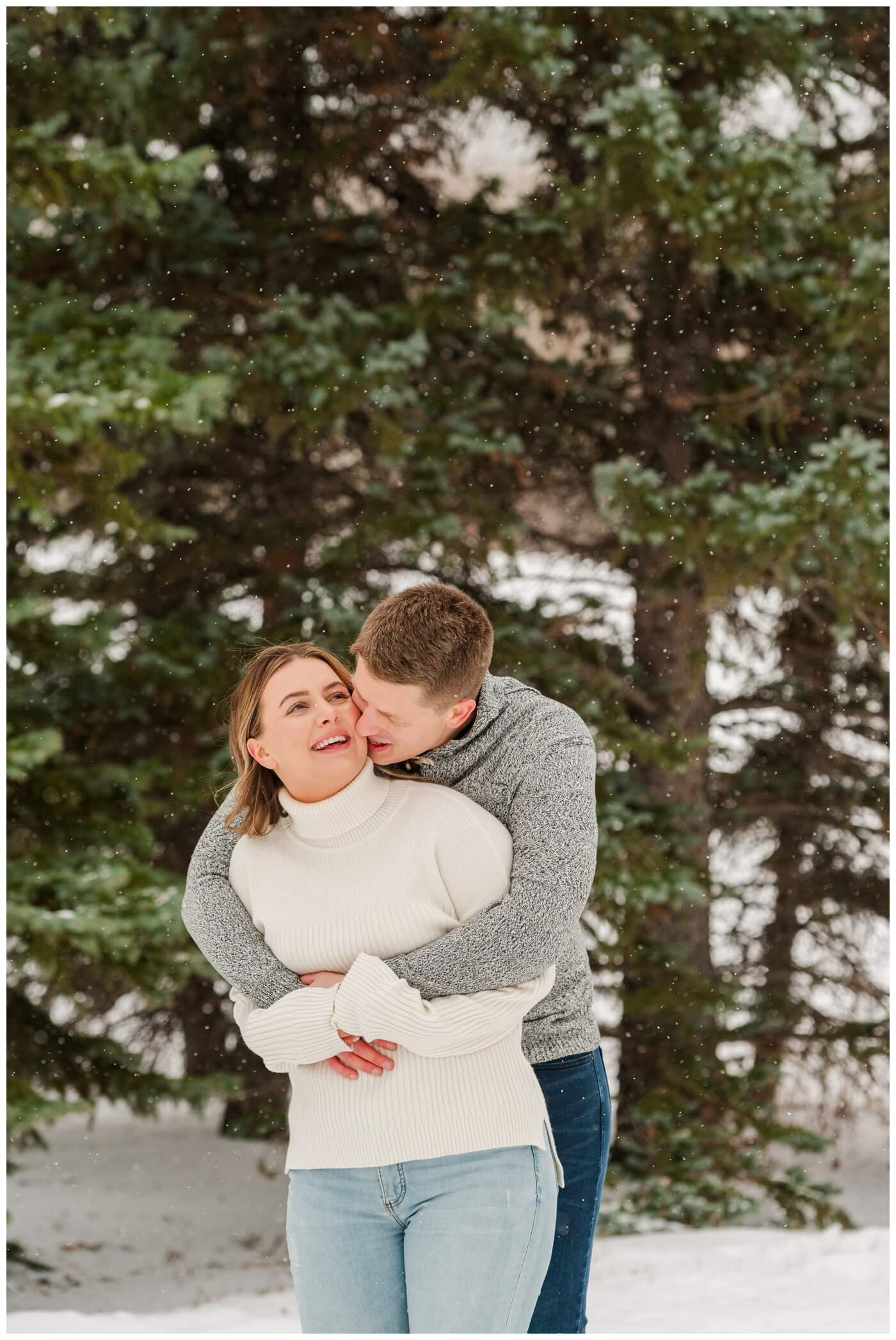 Michael & Briana - Engagement Session - 10 - UofR - Couple snuggling as the snow falls