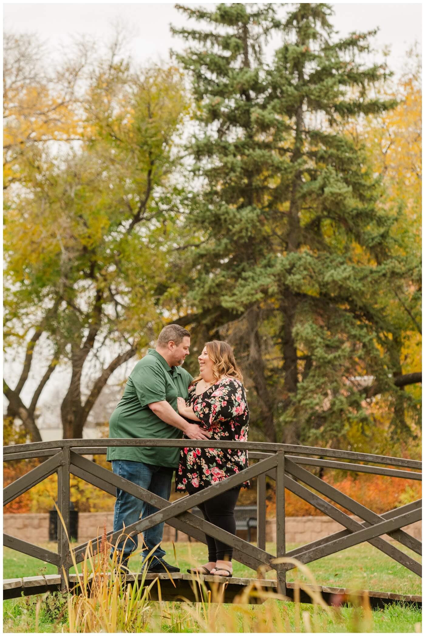 Scott & Ashley - Kiwanis Park Regina - 02 - Wife smiles at husband on bridge
