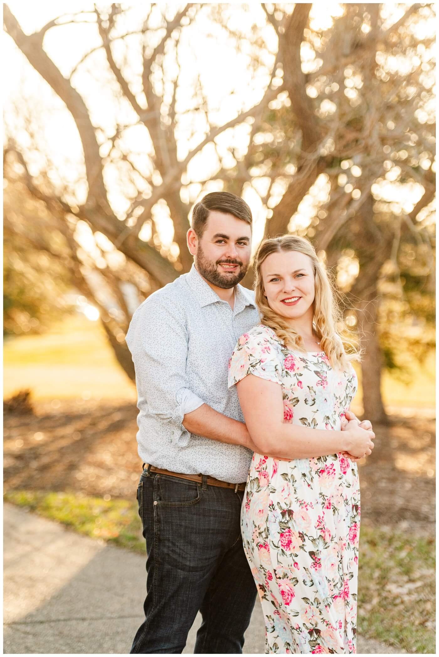 Darcy & Maddie - Regina Engagement - AE Wilson Park - 003 - Couple smile in the spring sunlight