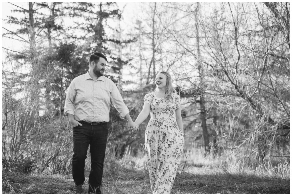 Darcy & Maddie - Regina Engagement - AE Wilson Park - 005 - Couple walks through the tall grass