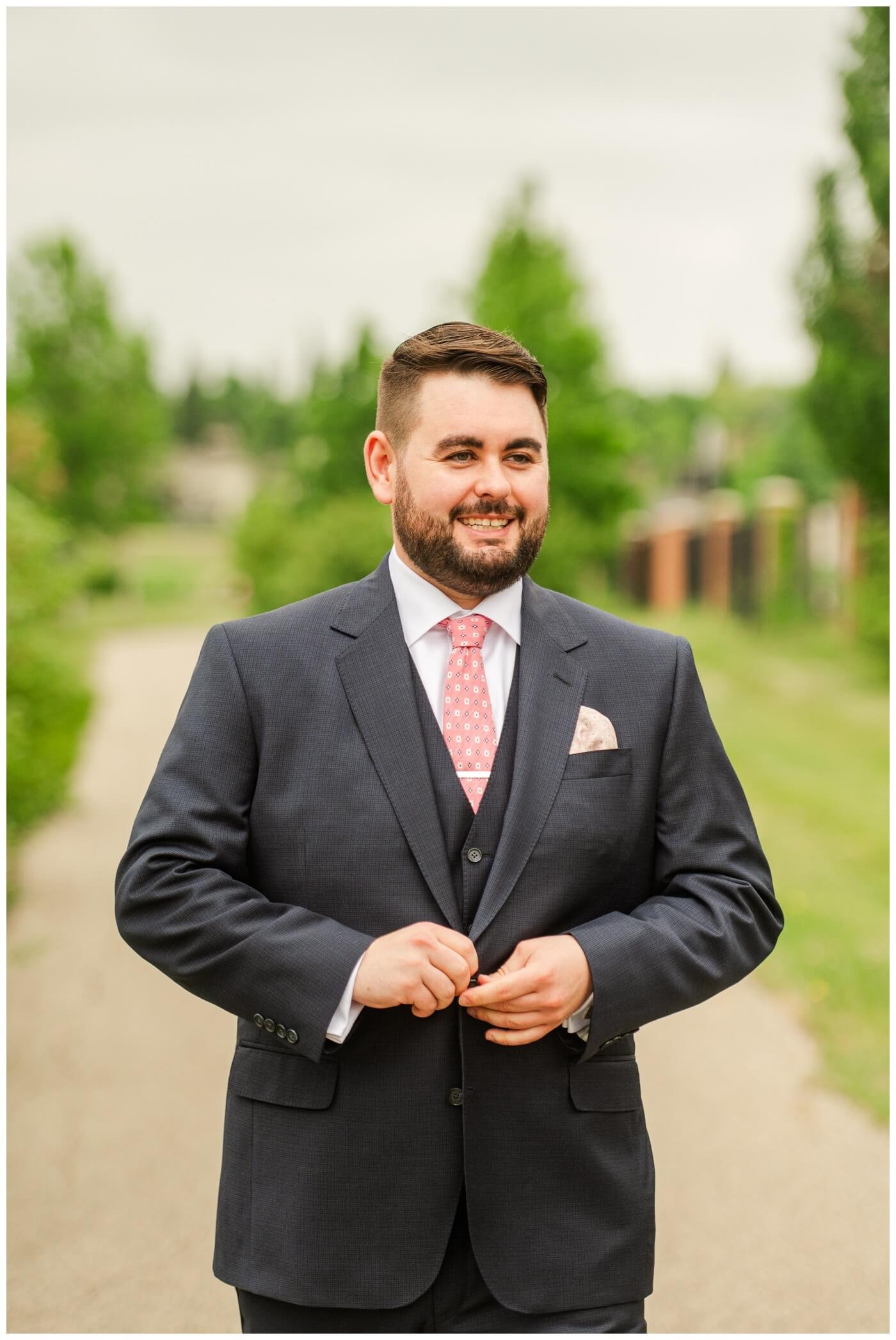Darcy & Maddie - Regina Summer Wedding - 003 - Groom in navy blue three piece suit