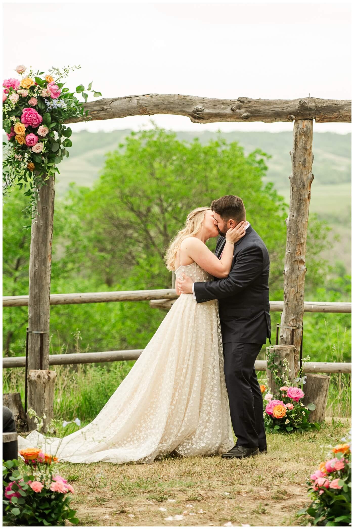 Darcy & Maddie - Regina Summer Wedding - 014 - Goodsman Farm - Bride and groom share a kiss
