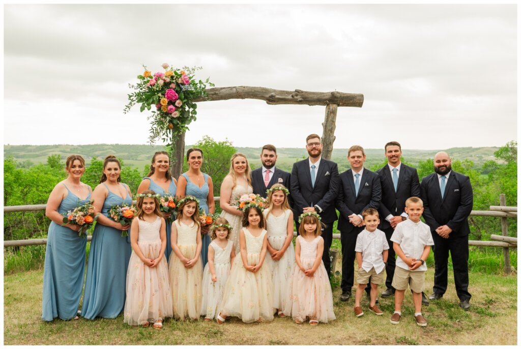 Darcy & Maddie - Regina Summer Wedding - 016 - Goodsman Farm - Wedding party at the ceremony alter