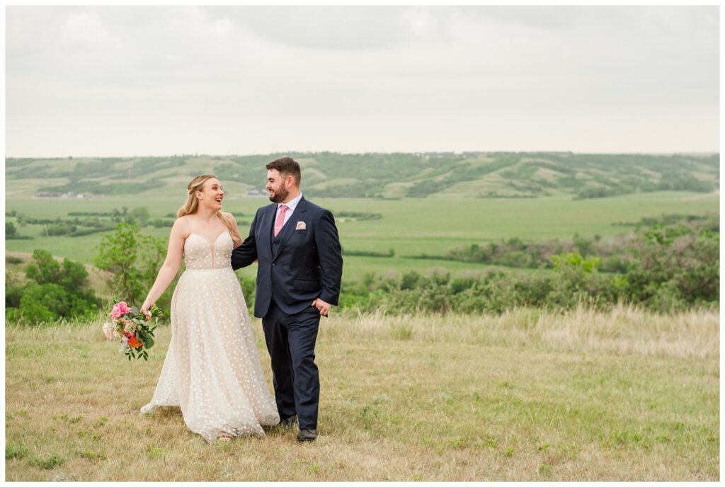Darcy & Maddie - Regina Summer Wedding - 021 - Goodsman Farm - Bride walks with her husband