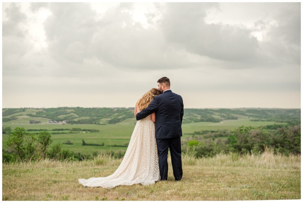 Darcy & Maddie - Regina Summer Wedding - 022 - Goodsman Farm - Bride & groom overlook the Qu'Appelle Valley