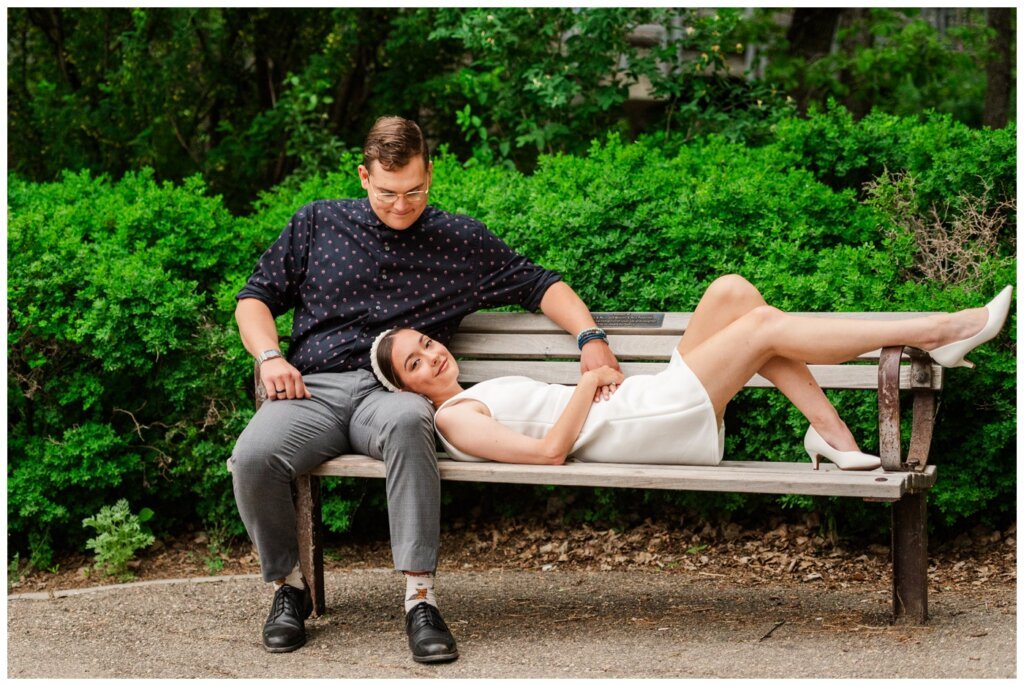 Skylar & Michaela- Regina Engagement - Wascana Park - 009 - Bride to be lays on bench