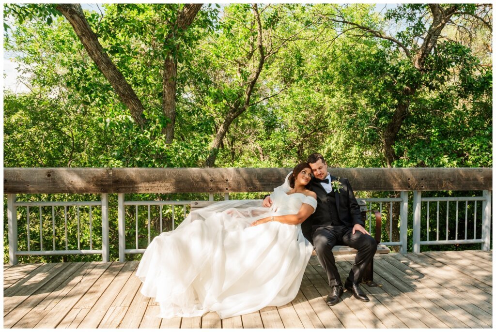 Derek & Danica - Regina Summer Wedding - 015 - Bride lays on bench in Wascana Park