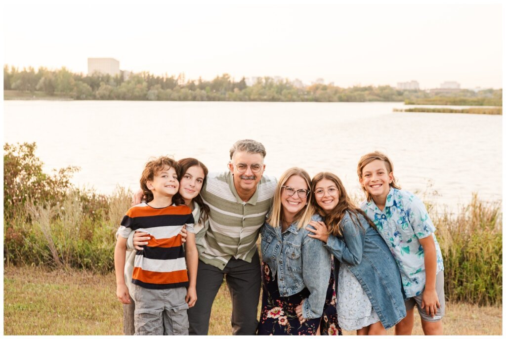 Dumont Family - Wascana Park - 010 - Family squeeze together in front of the lake