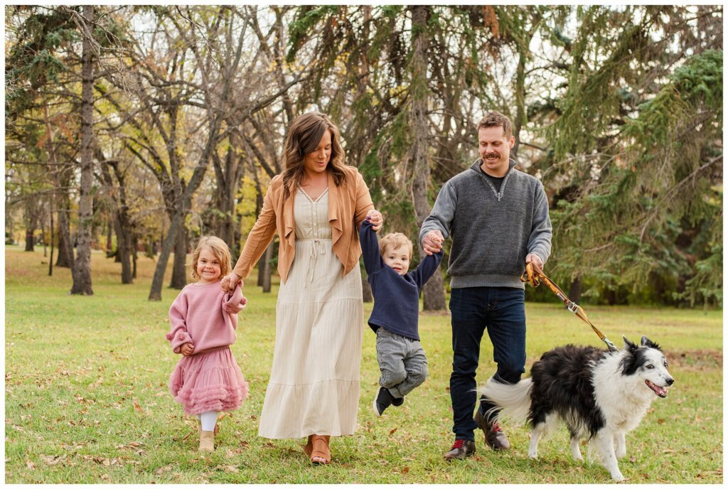 Filby Family - Wascana Park - 001 - Family walks with black & white dog
